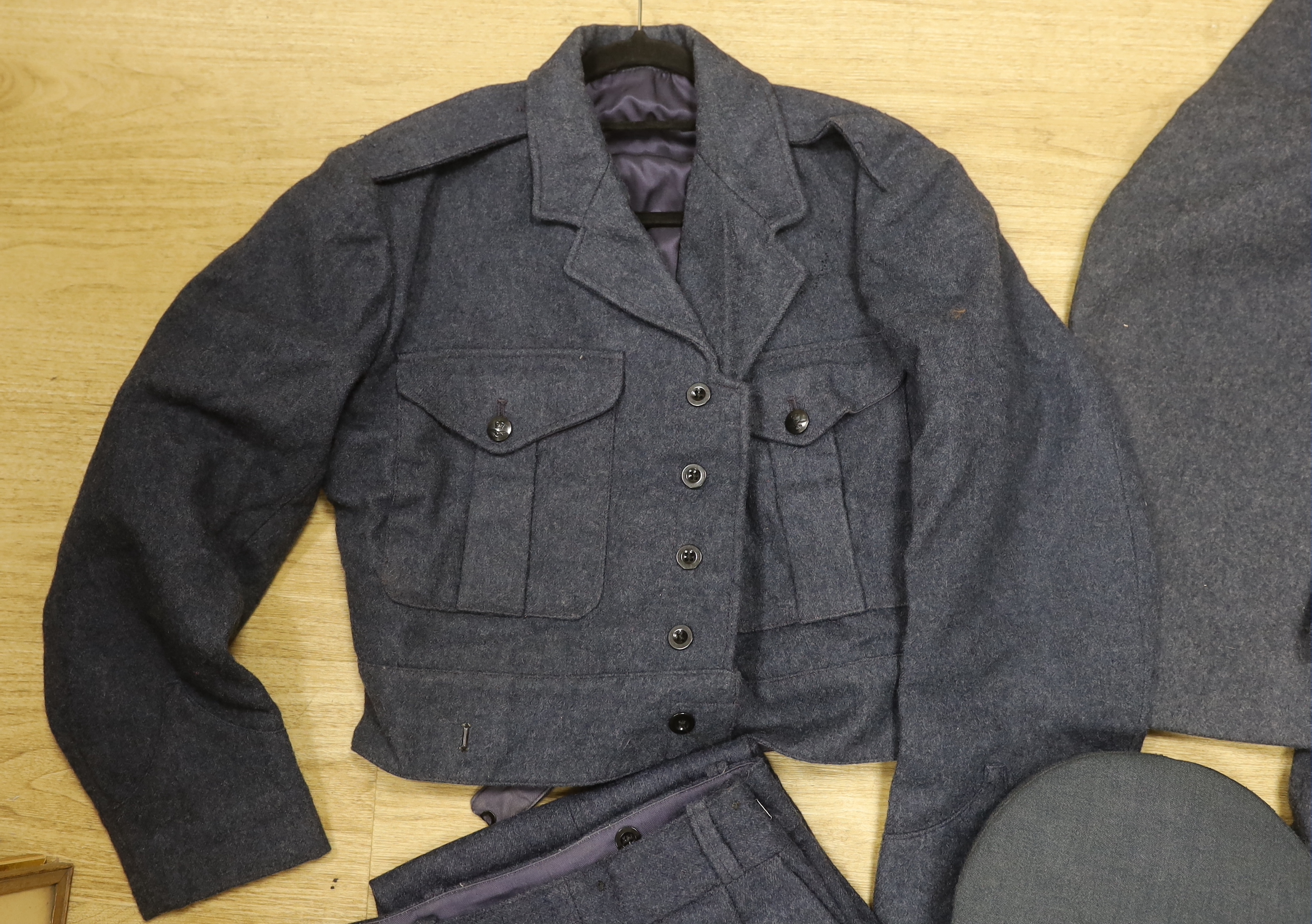 A 1960s RAF uniform comprising; great coat, blouse, cap and trousers, all with manufacturer’s labels, broad arrow markings, dates, etc.